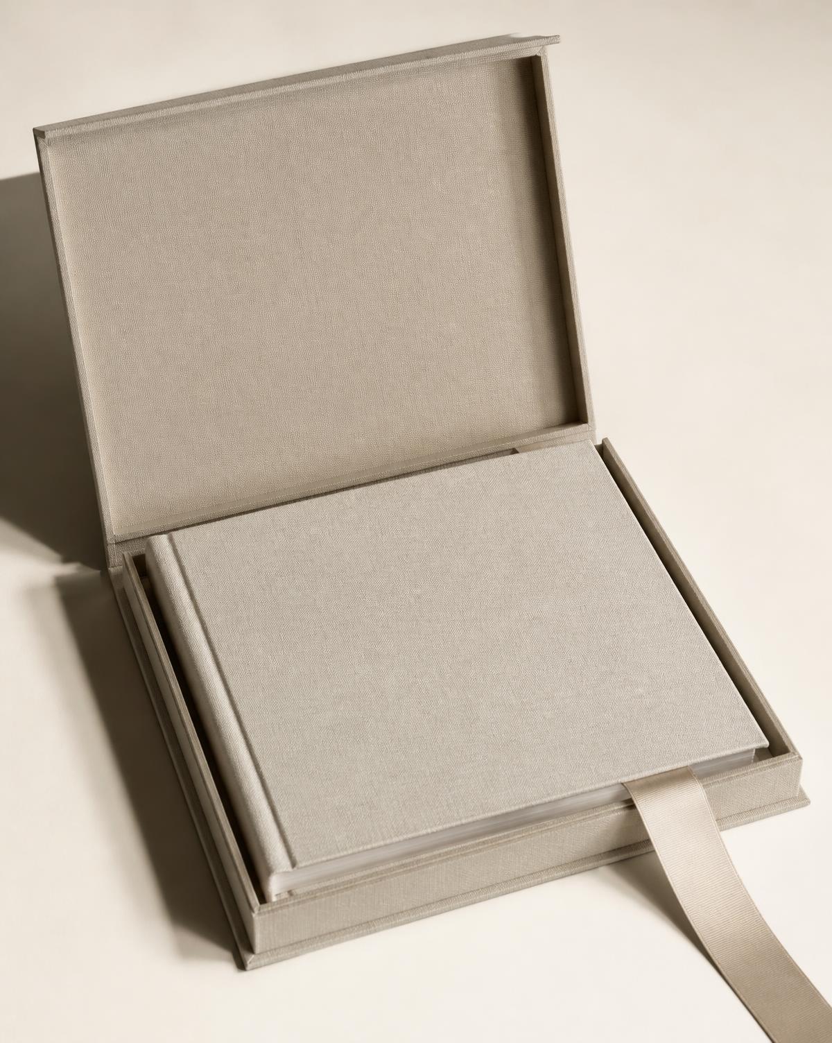 Álbum de boda dentro de un box abierto sobre fondo marfil